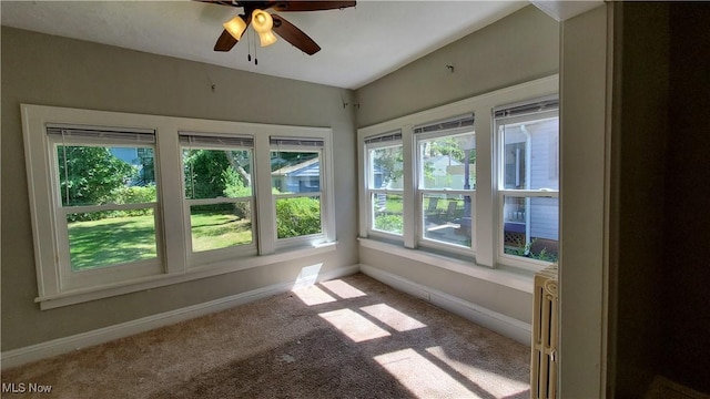 unfurnished sunroom featuring a ceiling fan