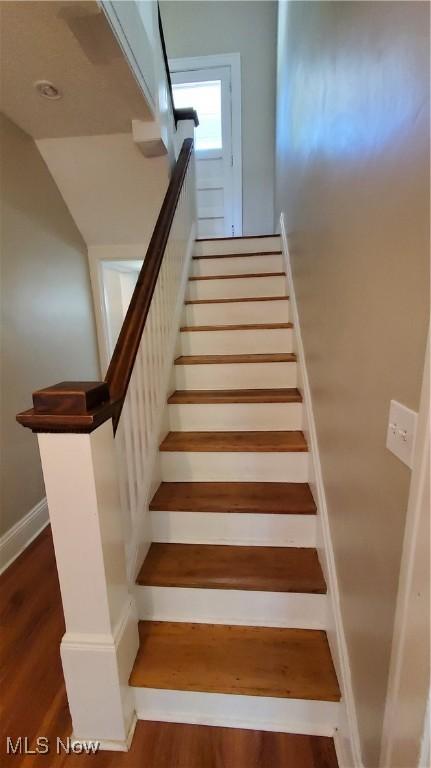 stairs with lofted ceiling and wood-type flooring