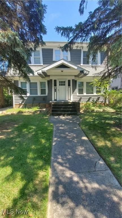 craftsman-style house featuring covered porch and a front lawn