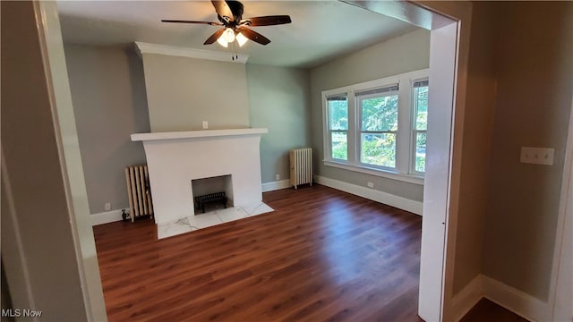 unfurnished living room with dark wood-type flooring, ceiling fan, and radiator