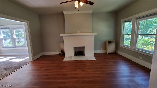 unfurnished living room with a fireplace with flush hearth, baseboards, radiator heating unit, and wood finished floors