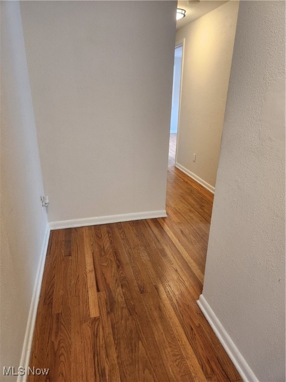 unfurnished room with baseboards and wood finished floors