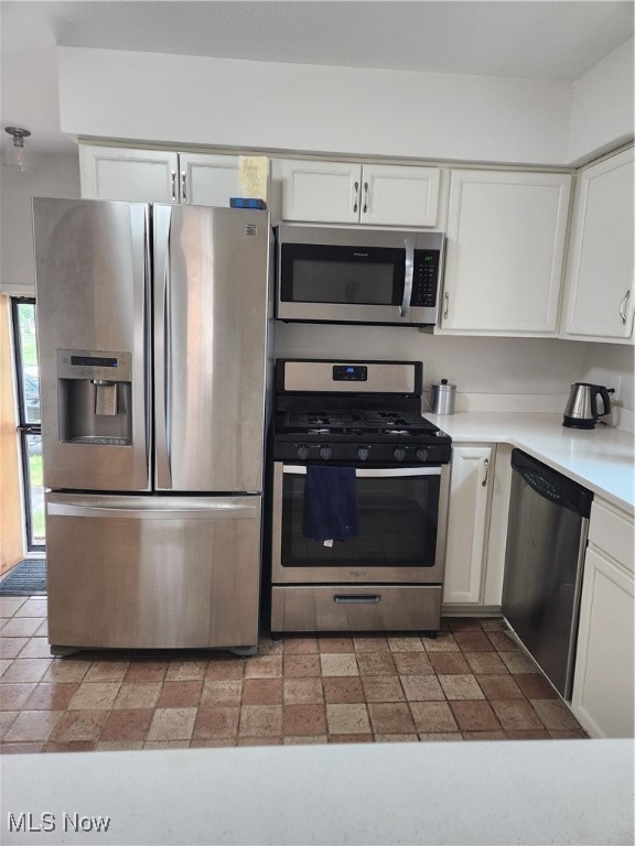 kitchen with white cabinetry, stainless steel appliances, and light countertops