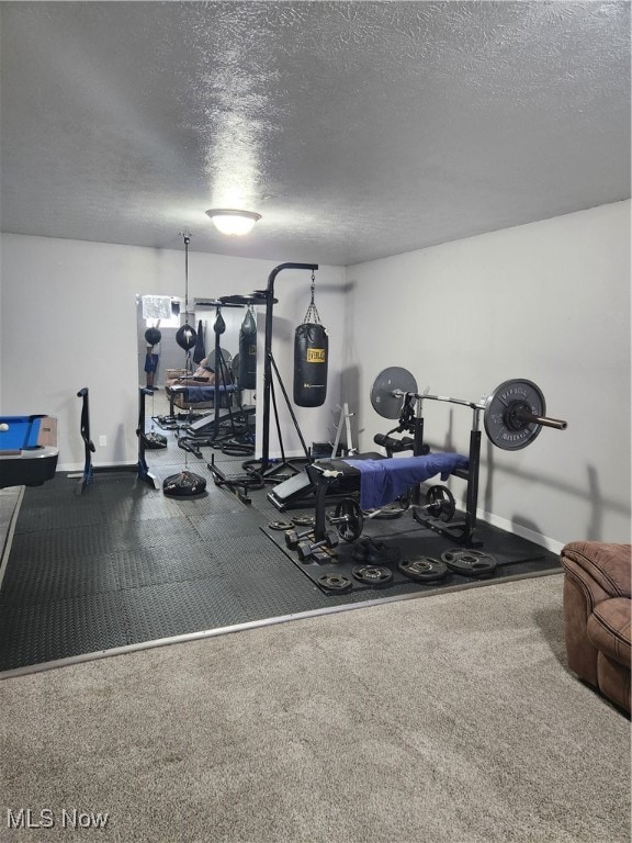 workout room with a textured ceiling and baseboards