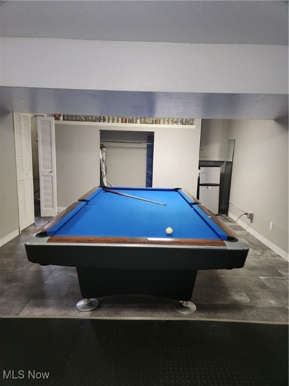 rec room featuring a dark floor, pool table, and baseboards