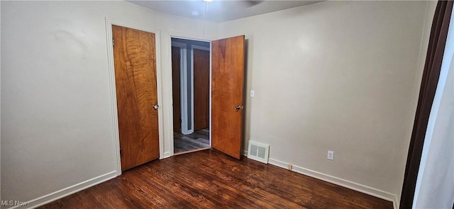 unfurnished room featuring dark wood-type flooring, visible vents, baseboards, and a ceiling fan