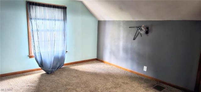 additional living space with vaulted ceiling, carpet flooring, visible vents, and baseboards