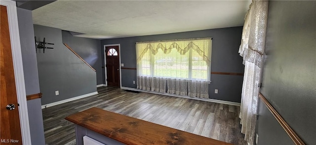 foyer with dark wood-style floors and baseboards