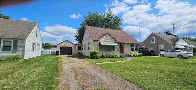 view of front facade with dirt driveway, an outbuilding, a garage, and a front yard