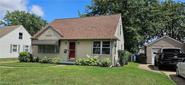 view of front of house with a detached garage, a front lawn, and roof with shingles