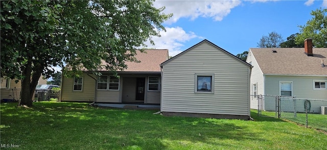 back of house featuring a yard and fence