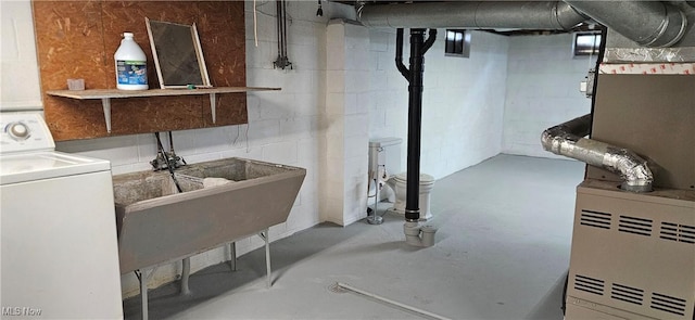 unfinished below grade area featuring washer / clothes dryer and a sink