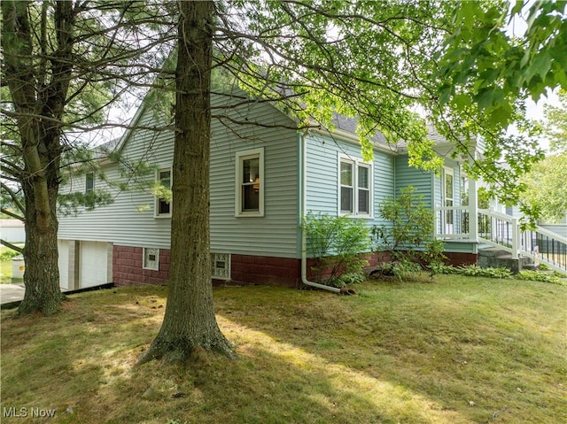 view of side of property featuring a lawn and a garage