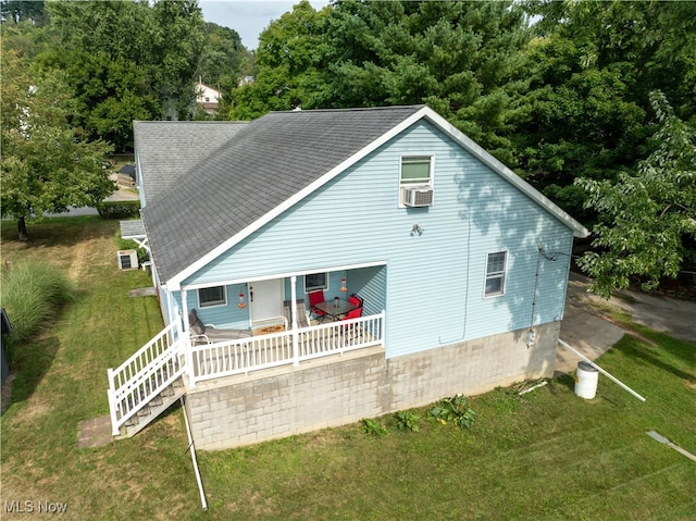 rear view of property featuring cooling unit, a yard, and a porch