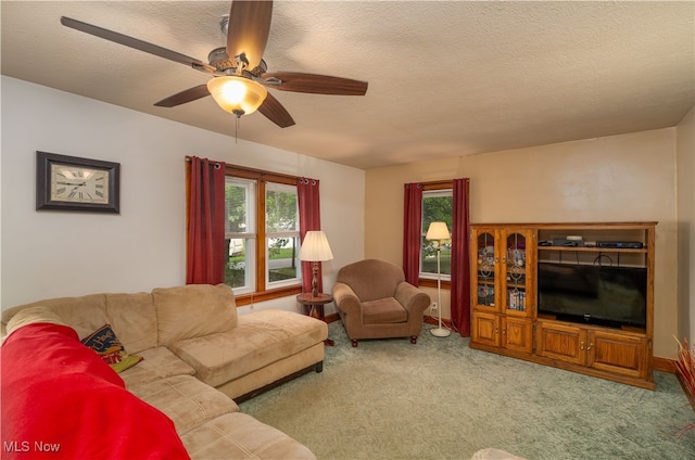 carpeted living room featuring ceiling fan and a textured ceiling