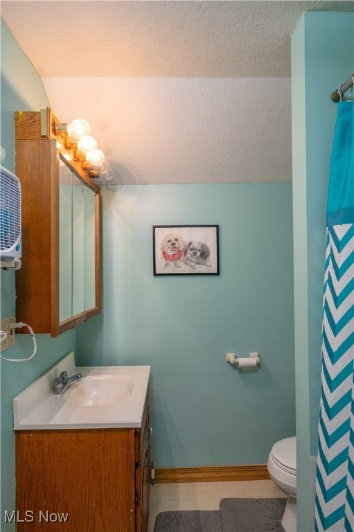 bathroom with tile patterned floors, toilet, a textured ceiling, and vanity