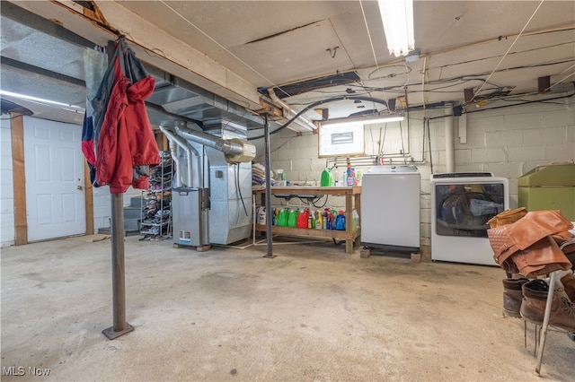 basement featuring heating unit and separate washer and dryer