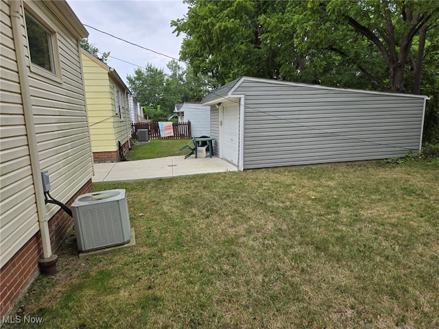 view of yard featuring an outbuilding, central AC unit, and a garage