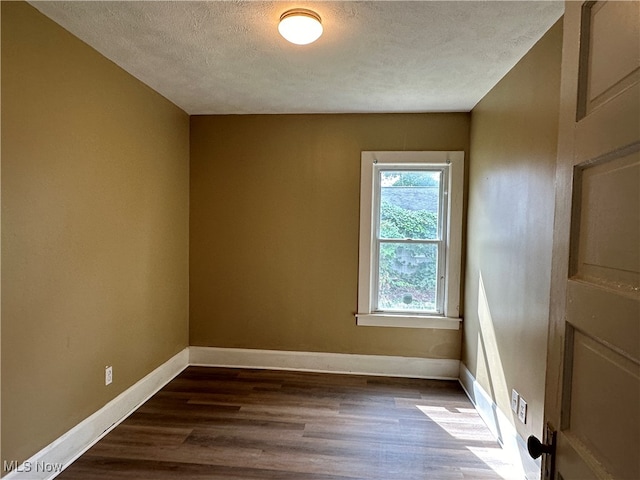 empty room with a textured ceiling and hardwood / wood-style flooring