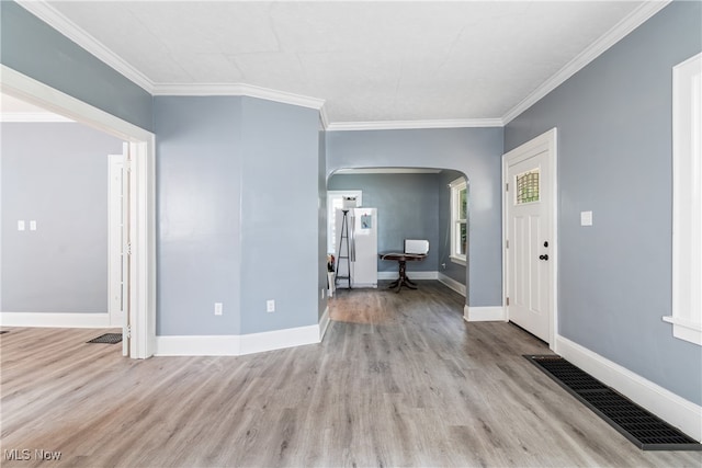 foyer entrance with crown molding and light hardwood / wood-style floors