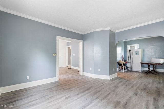 empty room featuring ornamental molding and light wood-type flooring