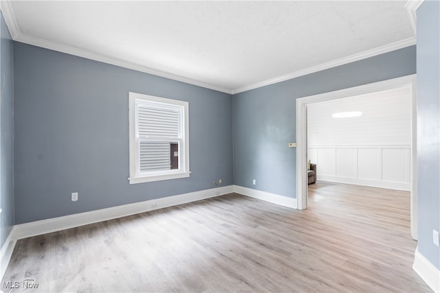 empty room featuring crown molding and light hardwood / wood-style floors