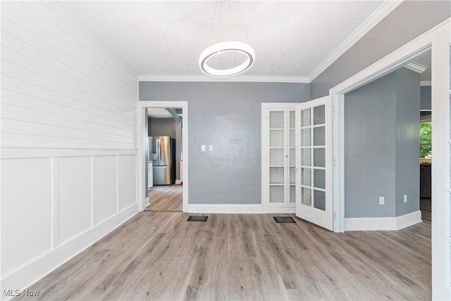 unfurnished room featuring light hardwood / wood-style flooring and crown molding