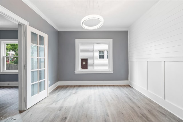 spare room featuring light wood-type flooring and crown molding