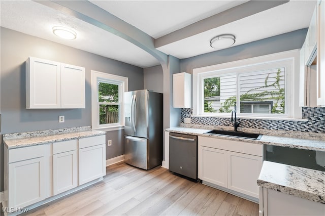 kitchen with white cabinetry, appliances with stainless steel finishes, sink, and a healthy amount of sunlight