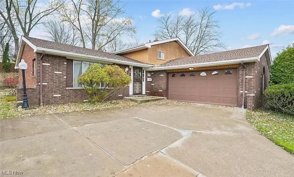 split level home with a garage and cooling unit