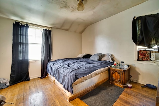 bedroom featuring ceiling fan, vaulted ceiling, and wood-type flooring