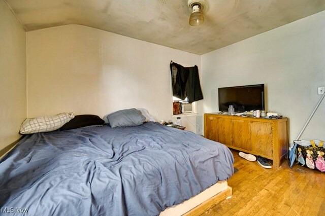 bedroom featuring hardwood / wood-style floors and vaulted ceiling