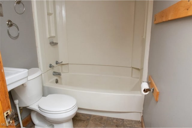 bathroom with bathing tub / shower combination and toilet