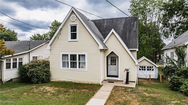 view of front of property featuring a garage, a front yard, and an outdoor structure