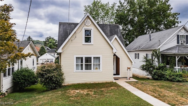 view of front of home featuring roof with shingles and a front yard