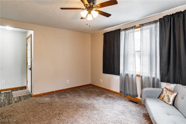 unfurnished room with carpet, ceiling fan, visible vents, and baseboards