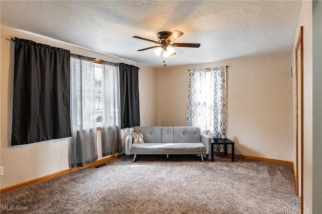 sitting room with a textured ceiling, carpet floors, visible vents, a ceiling fan, and baseboards