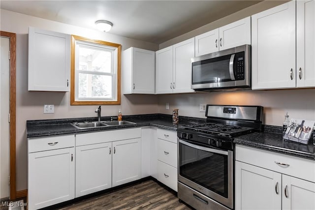 kitchen featuring appliances with stainless steel finishes, a sink, and white cabinetry