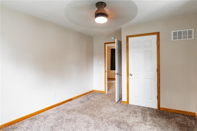 unfurnished bedroom featuring a ceiling fan, visible vents, light carpet, and baseboards