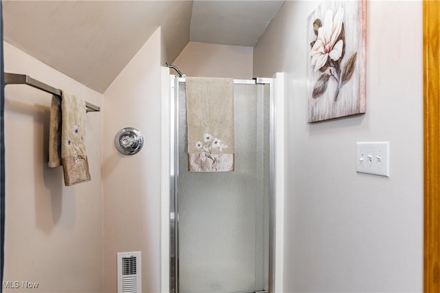 full bathroom featuring lofted ceiling, visible vents, and an enclosed shower