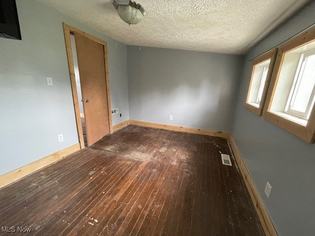 unfurnished room featuring a textured ceiling and wood-type flooring