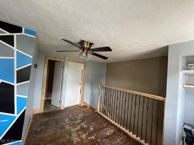 interior space featuring ceiling fan, hardwood / wood-style flooring, a closet, and a textured ceiling