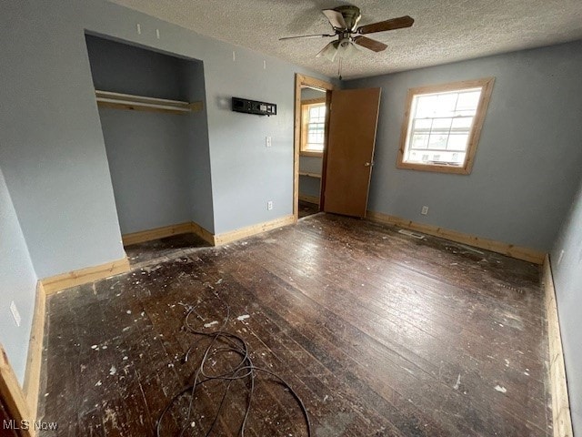 unfurnished bedroom featuring a textured ceiling, ceiling fan, and wood-type flooring