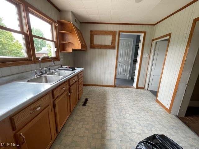 kitchen featuring sink, ornamental molding, and light tile patterned floors