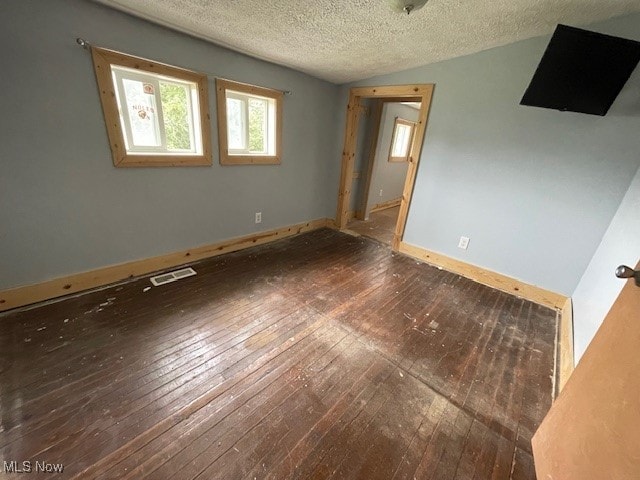 empty room with a textured ceiling and hardwood / wood-style flooring