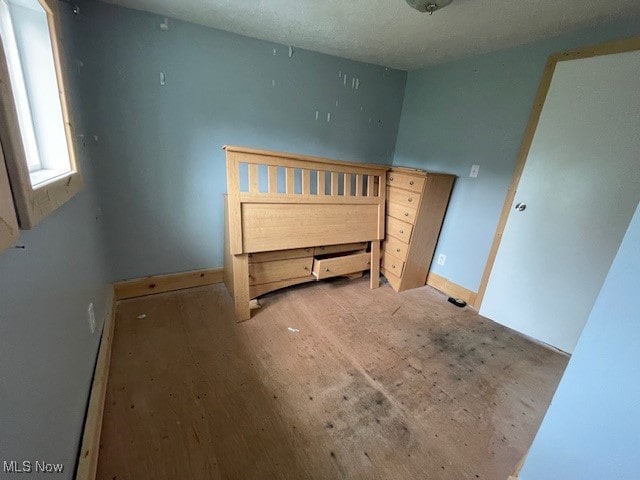 unfurnished bedroom featuring light hardwood / wood-style flooring and a textured ceiling