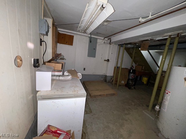 basement featuring water heater and electric panel