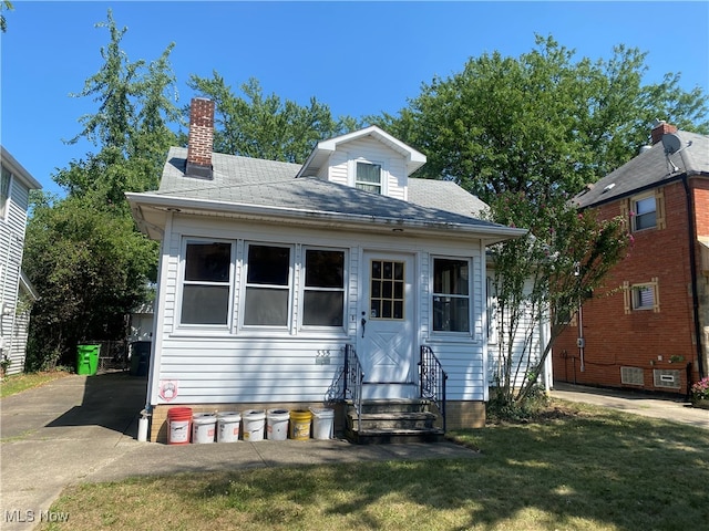 bungalow-style home with a front yard