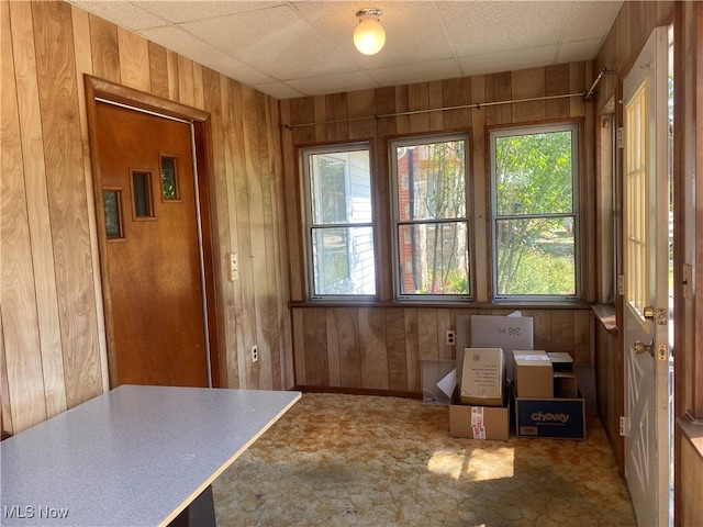 unfurnished sunroom with a healthy amount of sunlight and a drop ceiling