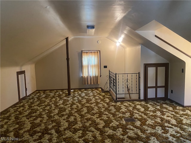 bonus room featuring vaulted ceiling and carpet